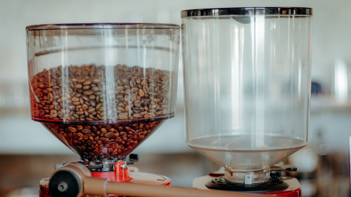 Coffee beans being added to the hopper of a bean to cup machine