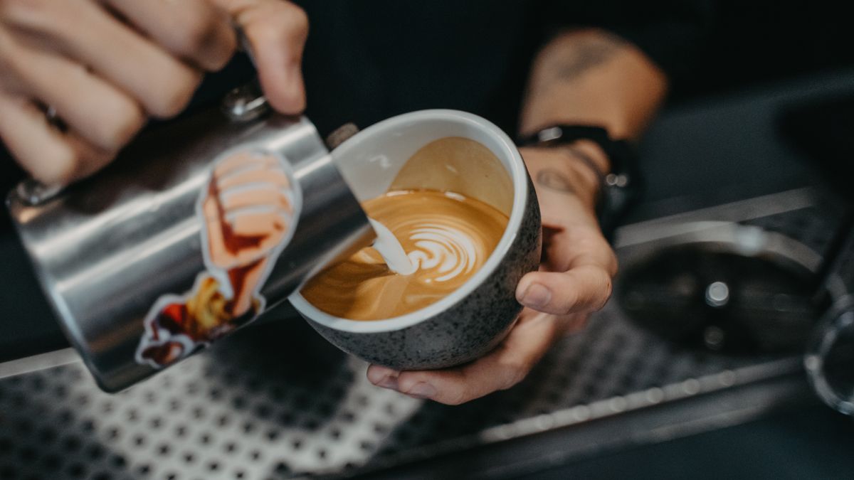 Fresh milk being poured into a latte from a bean to cup machine