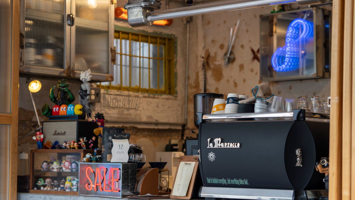 A traditional espresso machine and grinder setup on a coffee shop counter